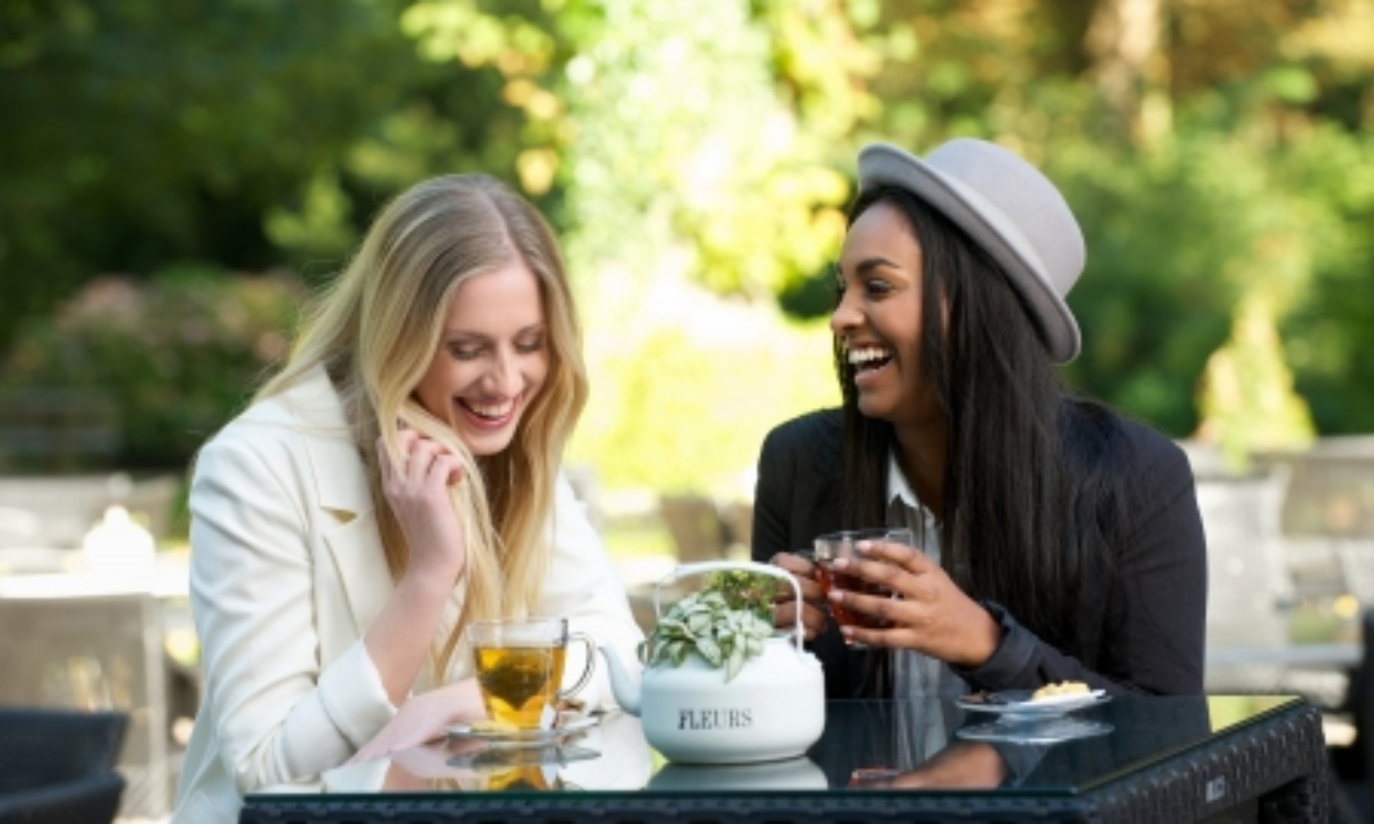 15895946 - two girls drinking tea and laughing outdoors